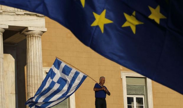 Greek flag - man holding Euro flag up top